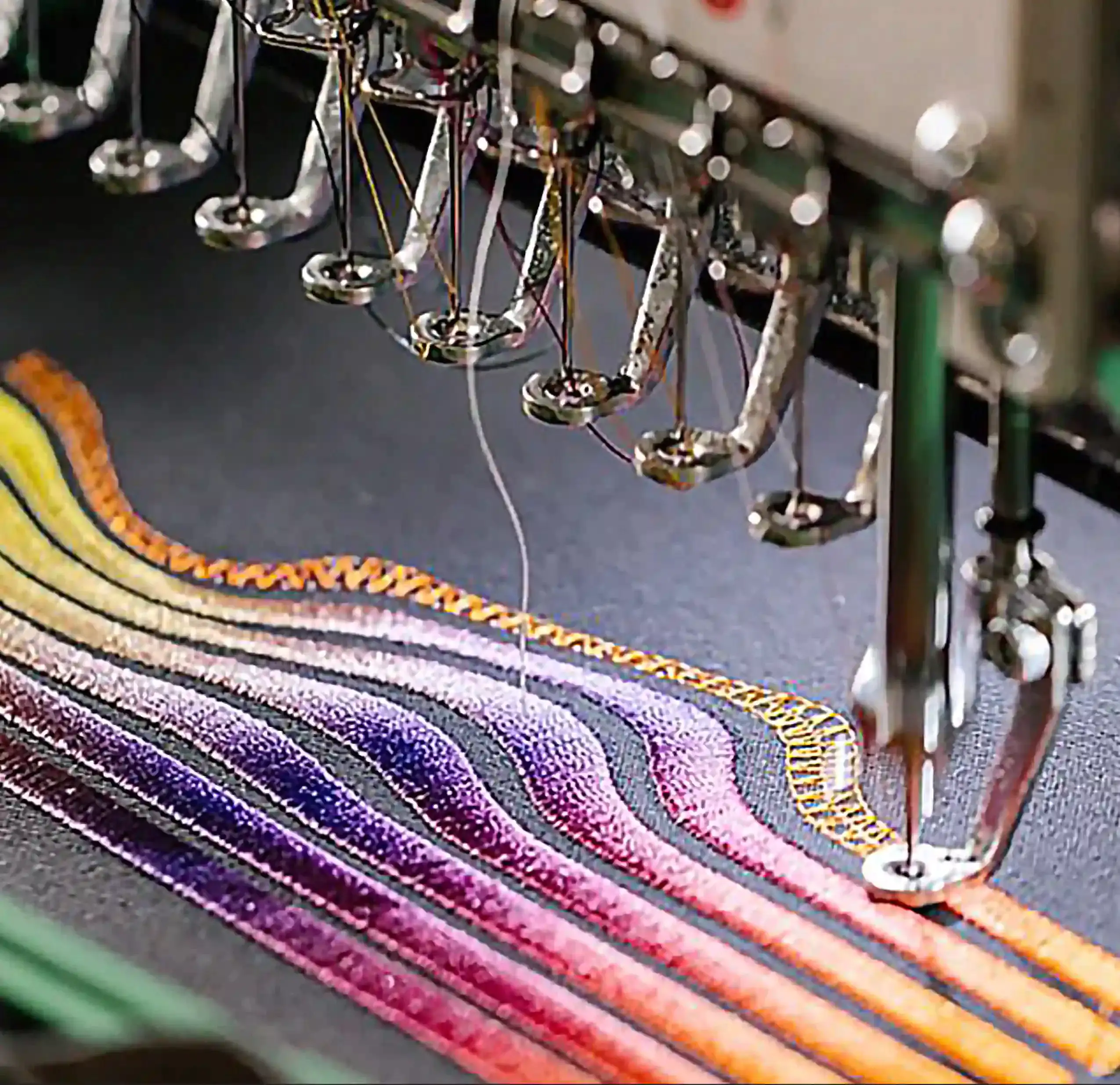 Close-up of custom embroidery machine stitching a colorful design on apparel, highlighting precision and craftsmanship – Custom Apparel, Screenprinting, and Embroidery services in Los Angeles.