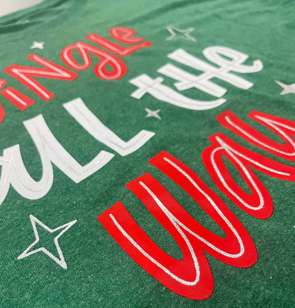 Festive custom screenprinted t-shirt with holiday-themed text design, highlighting expert screenprinting and custom apparel manufacturing – Custom Apparel, Screenprinting, and Embroidery for holiday collections.