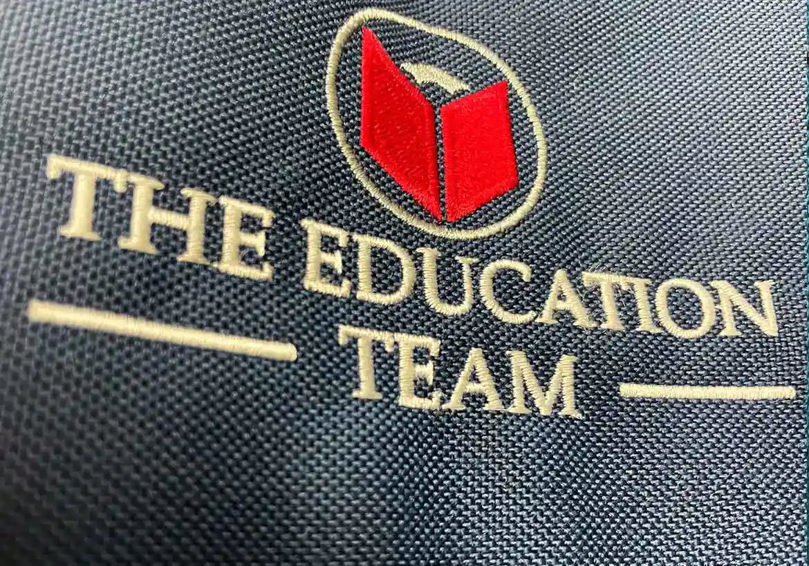 Custom embroidered 'The Education Team' logo on fabric, showcasing high-quality embroidery for school branding – Custom Apparel, Screenprinting, and Embroidery services in Los Angeles.