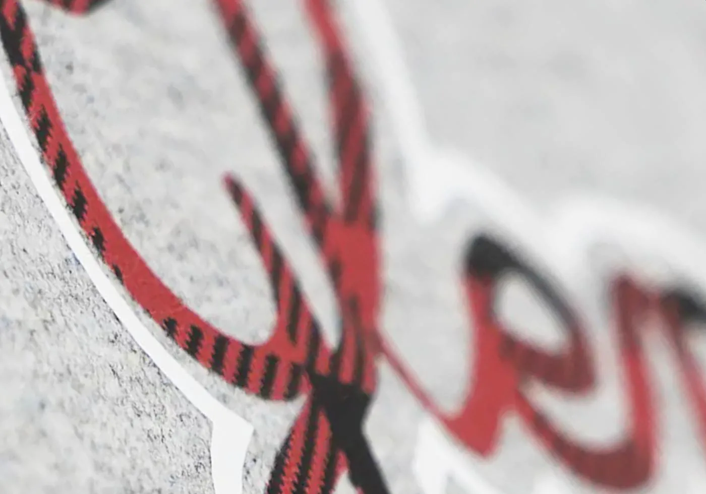 Close-up of custom screen printing with red and black plaid design on a gray fabric – high-quality screen printing for businesses and promotional products.