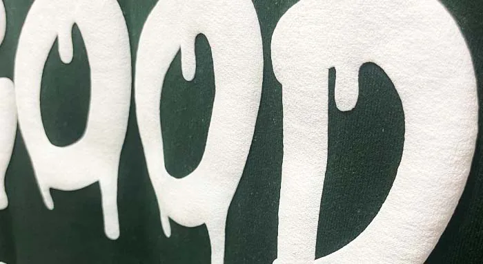 Close-up of bold, puff ink screenprinted lettering on custom apparel, showcasing high-quality print for business branding – Custom Apparel, Screenprinting, and Embroidery services in Los Angeles.
